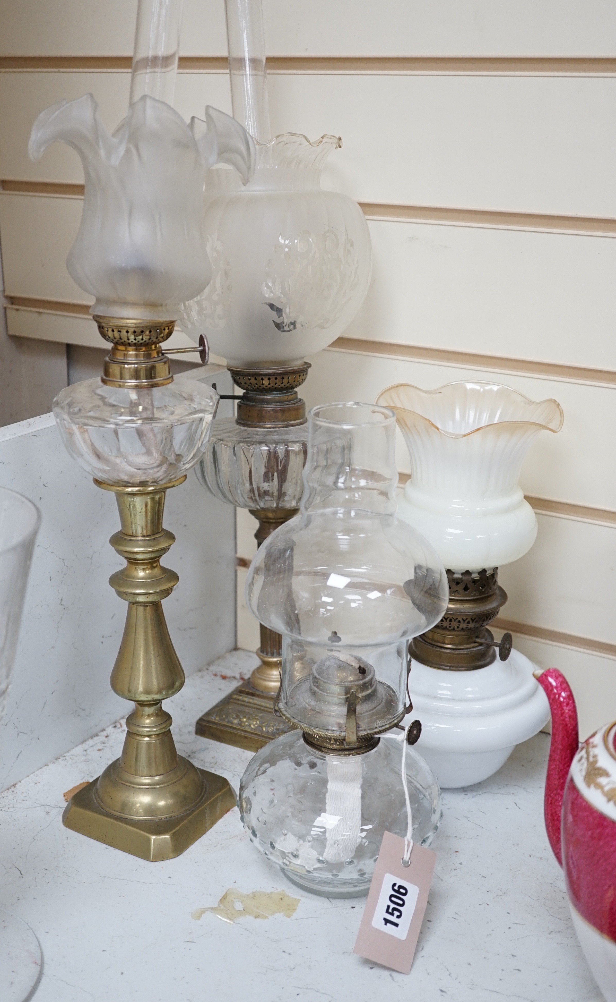 Four assorted glass and brass oil lamps, tallest 56cms high